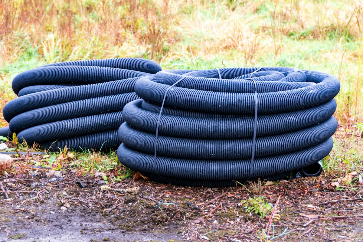 Coils of plastic pipe stacked on the ground