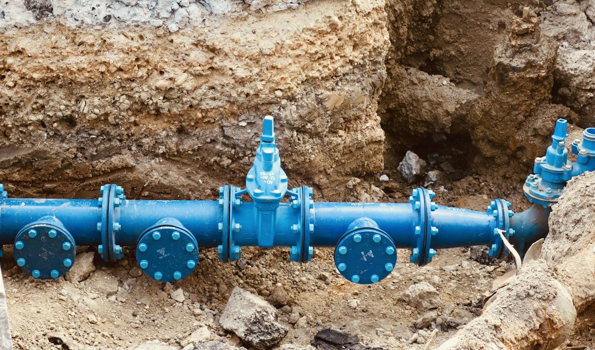 Blue water pipework with valves laid in a trench